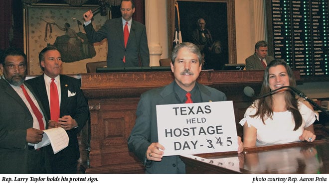 Rep. Larry Taylor holds his protest sign.