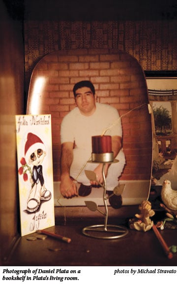 Photograph of Daniel Plata on a bookshelf in Plata's living room.