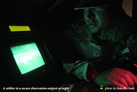 A soldier in a secure observation outpost at night, photo by Jana Birchum