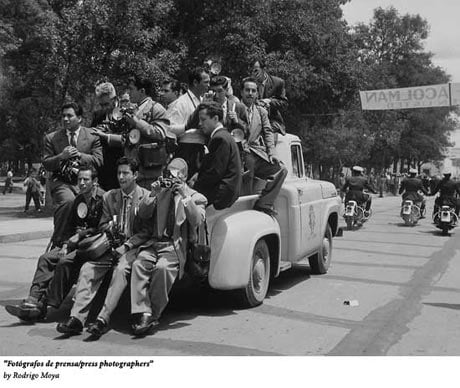 Fotografos de prensa by Rodrigo Moya. An old photo of several Mexican press photographers riding in the bed of a pickup truck in what looks like some sort of parade or procession