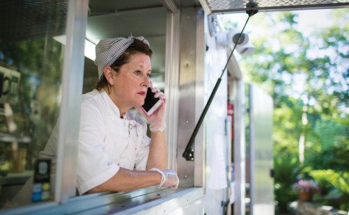Joan Cheever — on phone in her food truck.