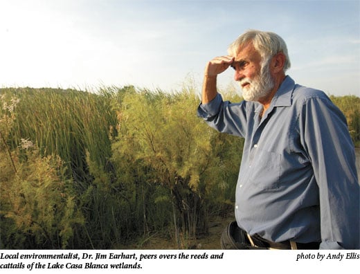  Local environmentalist, Dr. Jim Earhart, peers overs the reeds and cattails of the Lake Casa Blanca wetlands.
