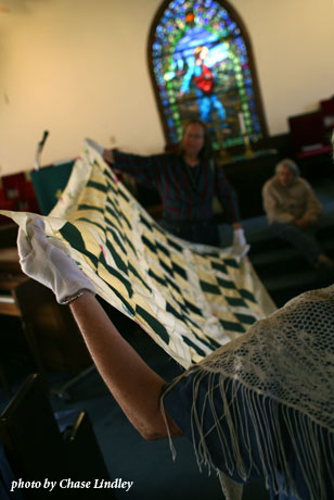 2 women folding a quilt, photo by Chase Lindley