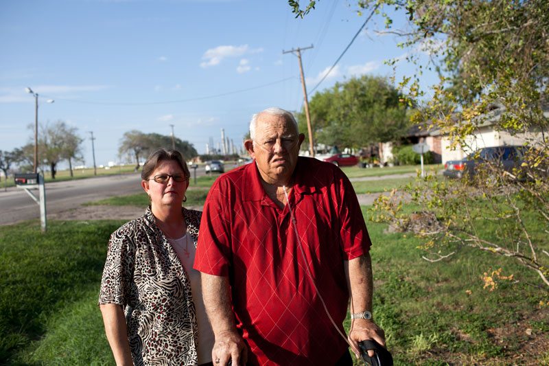 Bobi and Jim Miller in their yard. The Flint Hills Resources West Plant stands in the background