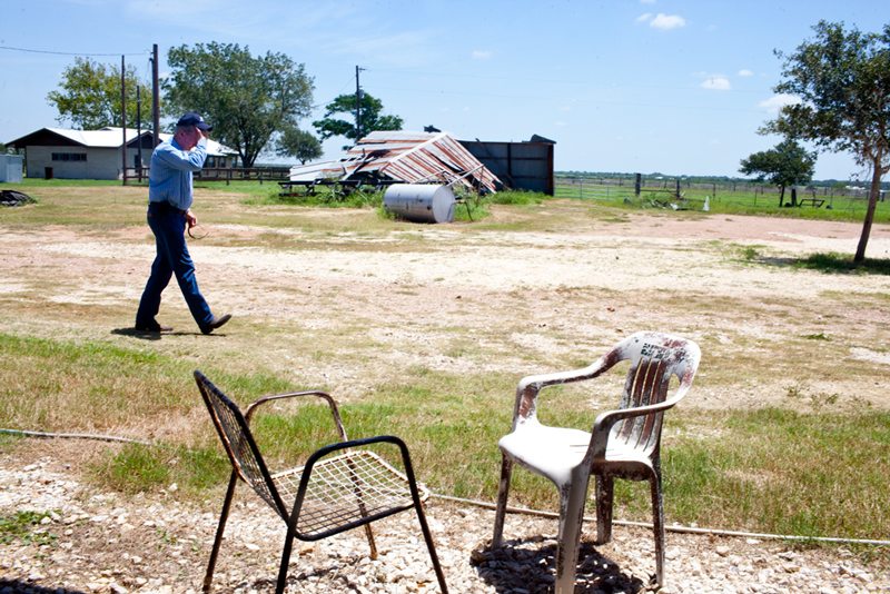 Denis Wauson walks past empty chairs