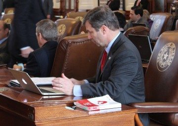 Rep. David Simpson (R-Longview) looks at HR 4 and the proposed amendments at his desk on the House floor Wednesday.