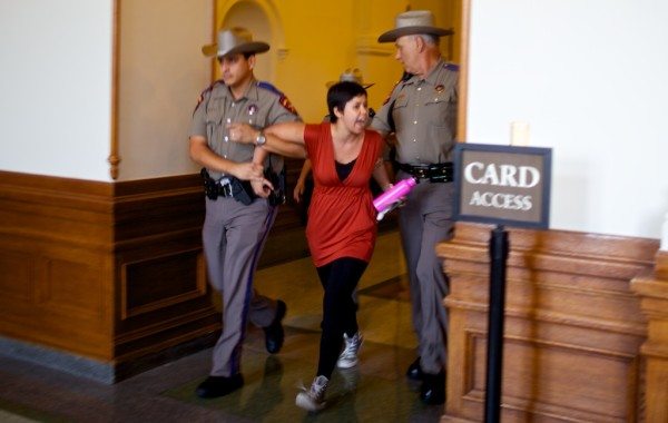 Troopers lead a woman out the Capitol's east doors Friday evening.