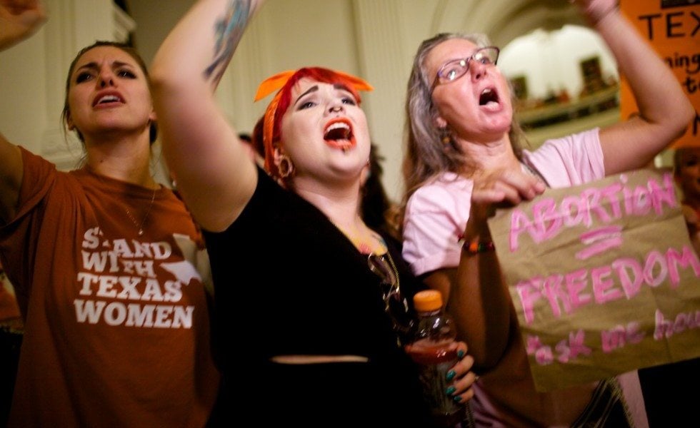 Abortion-rights protesters chant outside the Senate chamber minutes before lawmakers sent House Bill 2 to Governor Perry's desk for his signature in 2013.