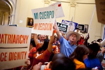 Activists chant and yell in the Capitol rotunda as the House debates new abortion restrictions.