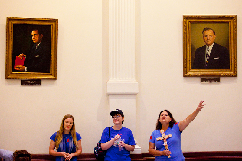 Blue-shirted demonstrators sang and prayed in the Capitol rotunda Tuesday during House debate on sweeping new abortion restrictions.