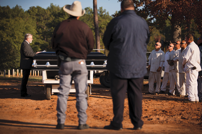 Prison Chaplain Larry Hart leads guards and inmate trusties in prayer during a burial at TDCJ’s Captain Joe Byrd Cemetery in Huntsville.