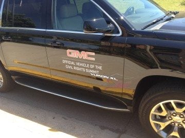 "GMC: Official Vehicle of the Civil Rights Summit." Two General Motors executives were speakers at the summit.