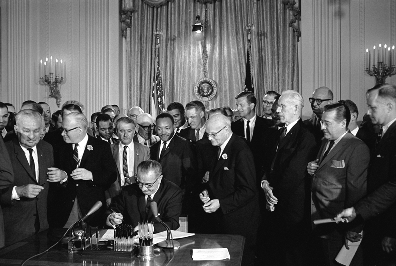 President Lyndon B. Johnson signs the Civil Rights Act of 1964.