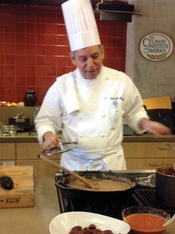 Chef/scholar/author Adán Medrano demonstrates well-fried beans, chile ancho adobo and other Texas Mexican recipes to faculty and staff at the Culinary Institute of America in San Antonio.