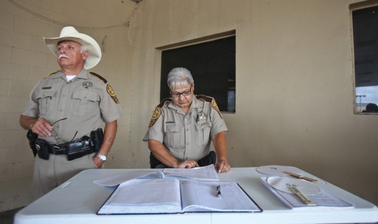 Hidalgo County sheriff’s deputies T.J. Tejerina and Aida Bravo conduct a June tax foreclosure sale. 