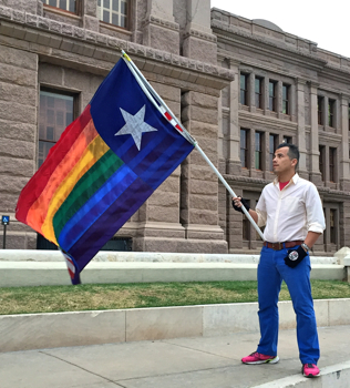 Activist Omar Lopez waves a Texas-gay Pride hybrid flag during Saturday's rally at the Capitol.