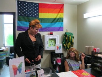 Thrive Youth Center residents Chanel Versace, left, and Damien Pena, who both identify as transgender, talk behind the front desk in San Antonio last month.