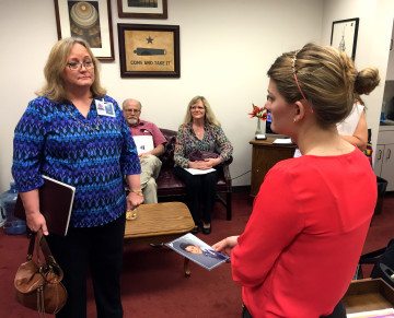 Ann Elder, left, shares a photo of her transgender son with a staffer for Rep. Dennis Paul (R-Houston) as Mitchel Roth and Lisa Mauldin look on during Monday's lobby day at the Texas Capitol.
