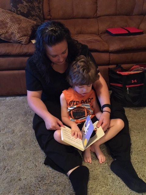 A special needs child reads at home.