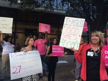 Pro-choice protester holds a sign outside the Bank of America building in Austin: "I asked God, She's pro-choice."