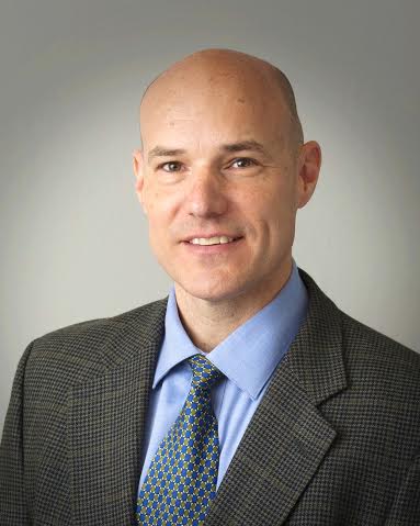 Photograph of Doug Smith, smiling and wearing a suit.