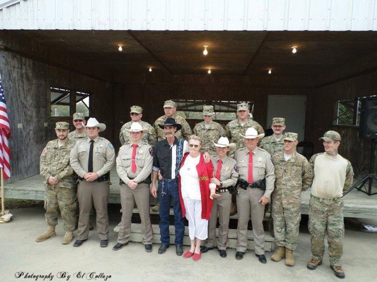 Sheriff Elliott and her deputies meeting with members of a local Edwards County militia. She and its leader, Rick Light (black hat), are flanking an unknown woman.