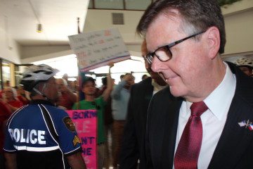 Lieutenant Governor Dan Patrick walks past pro-LGBT protesters Tuesday inside the Fort Worth ISD Administration Building. He hosted a press conference where he spoke against the district’s new guidelines protecting transgender students, which he said could be used as a springboard to further advance his conservative "school choice" plan.