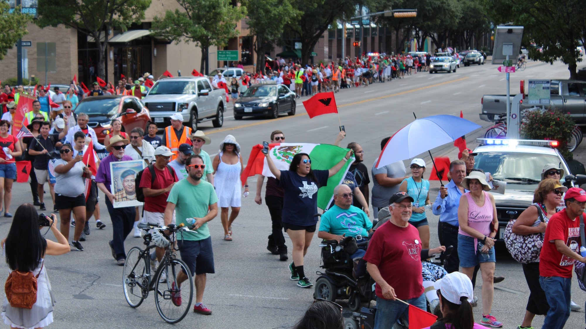 Hundreds of demonstrators walked four miles from St. Edward's University to the Texas Capitol, partially following in the footsteps of marching labor strikers in 1966.