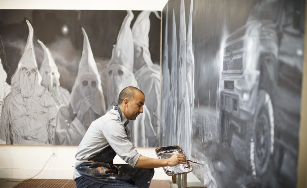 Mexican American artist Vincent Valdez works on his eight-panel painting of modern day klansmen in his studio in San Antonio.