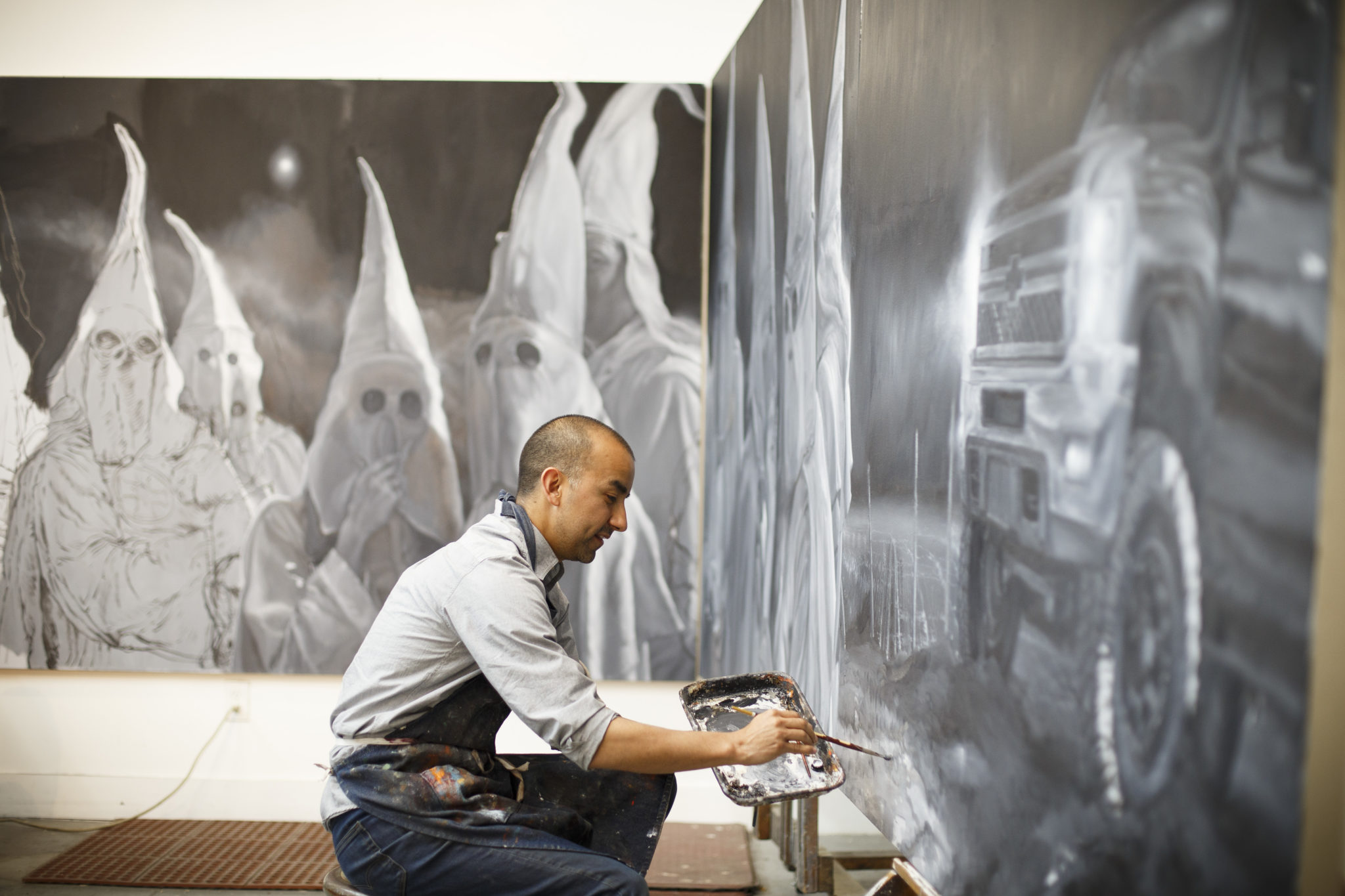 Mexican American artist Vincent Valdez works on his eight-panel painting of modern day klansmen in his studio in San Antonio.