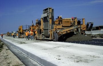 Workers pour concrete onto I-10 in Texas. The batch plants that produce concrete are often located close to neighborhoods and emit thousands of tons of pollutants. 