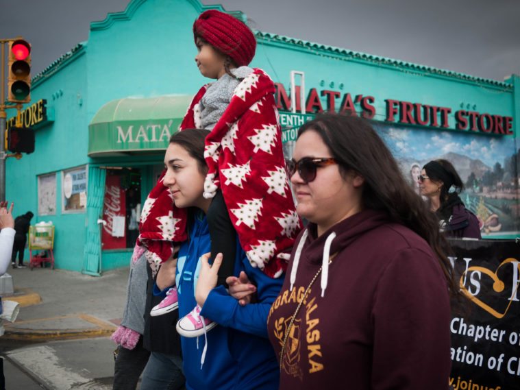 A family moves through the streets of El Paso during the Women's March.