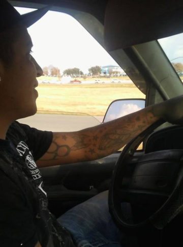 Everardo driving in December -- 2 months before being deported. Tattoos include Jesus on right shoulder and butterfly and stars down left arm.