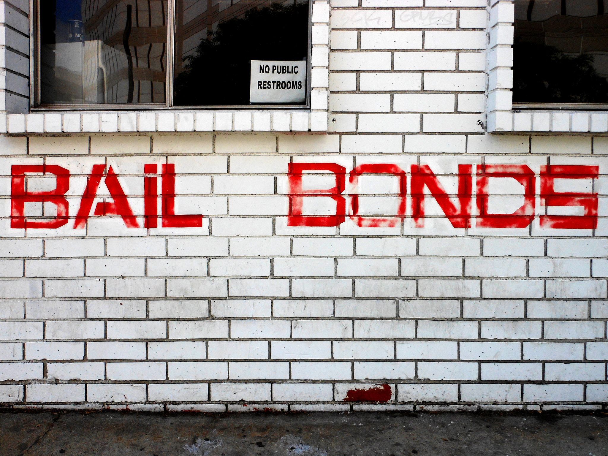 A brick wall with the words "Bail Bonds" painted in red capital letters