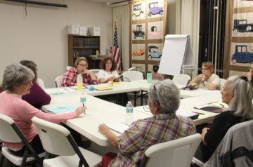 Ginger Redden (center, left) and other Bastrop County Indivisible volunteers brainstorm ACA outreach at the Smithville Public Library.
