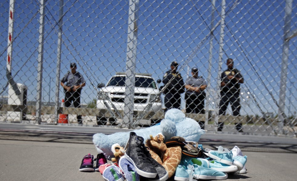 Shoes and a teddy bear, brought by a group of U.S. mayors, are piled up outside a holding facility for immigrant children in Tornillo.