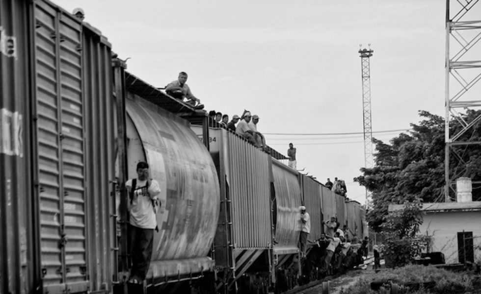 Migrants riding atop <em>La Bestia</em> in Mexico.