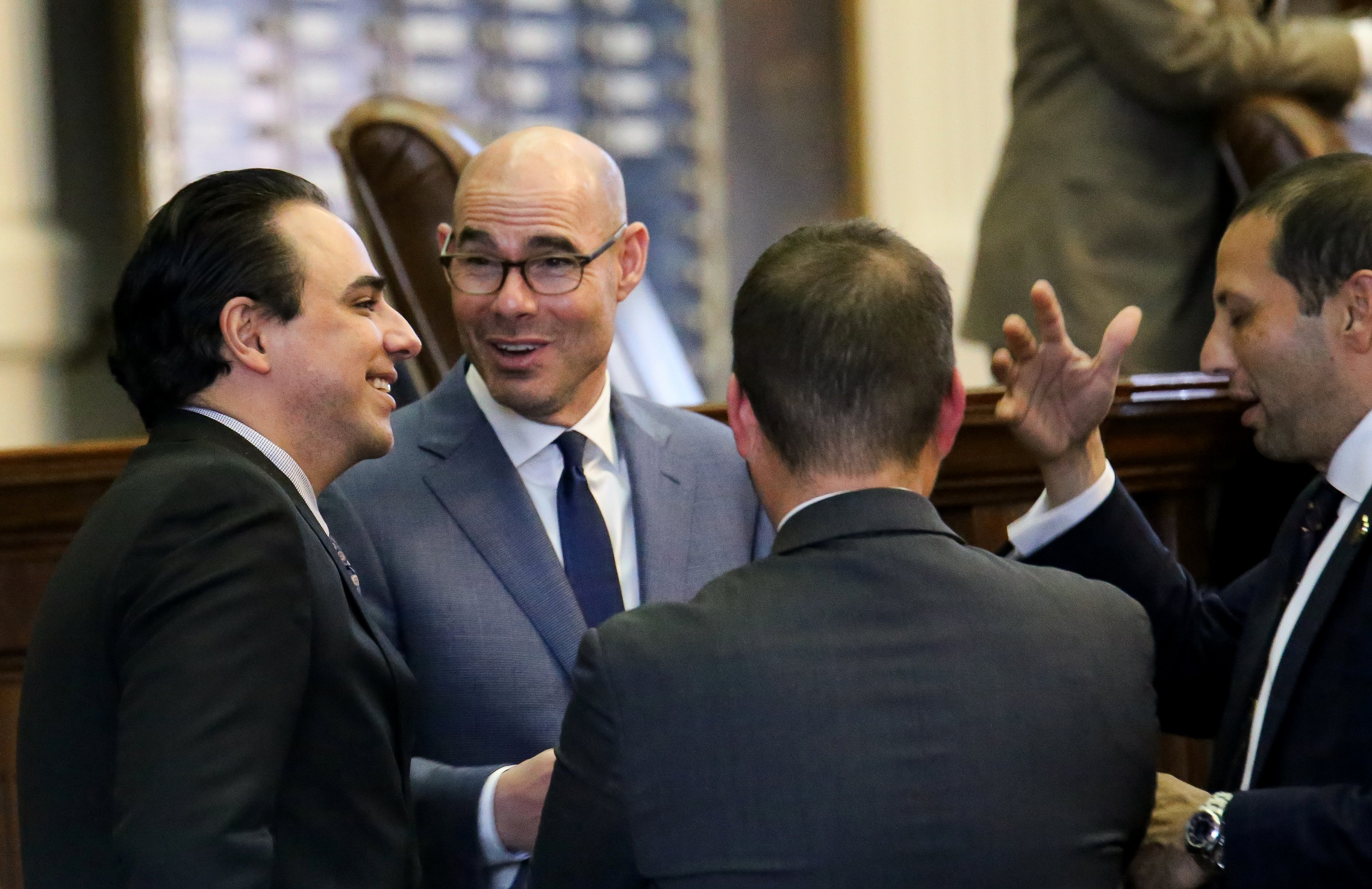 Texas House Speaker Dennis Bonnen (center) speaks with state Representatives Terry Canales (left) and Poncho Nevárez (right).