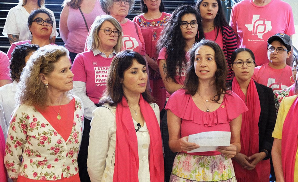 Lawmakers and advocates outside the Texas House chamber don pink in support of Planned Parenthood as the Texas House debated a bill to further defund the organization during the 2019 session.
