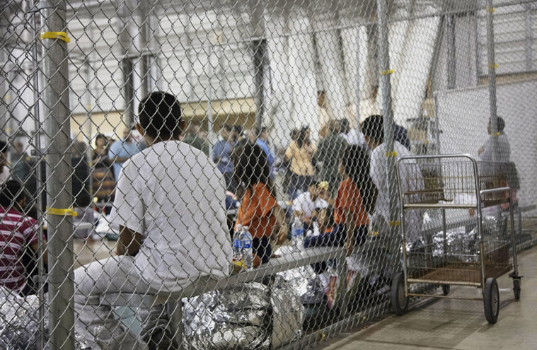 Migrants sit in one of the cages at the CBP detention facility in McAllen, Texas.