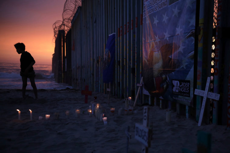 A youth stands by the border fence that separates Mexico from the United States.