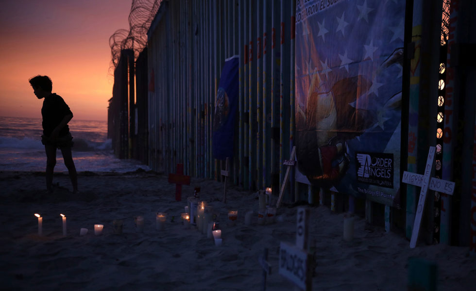 A youth stands by the border fence that separates Mexico from the United States.