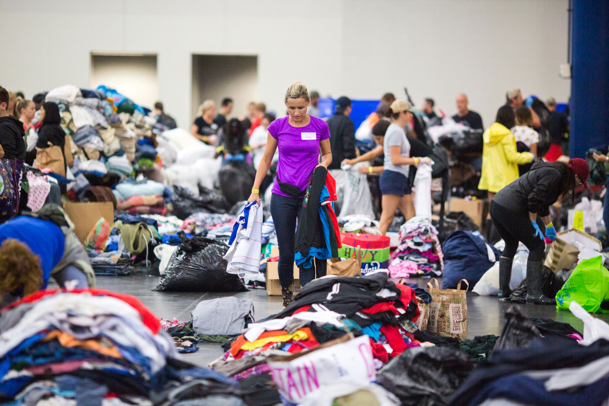 A volunteer sorts through donated clothes at the George R. Brown Convention Center.