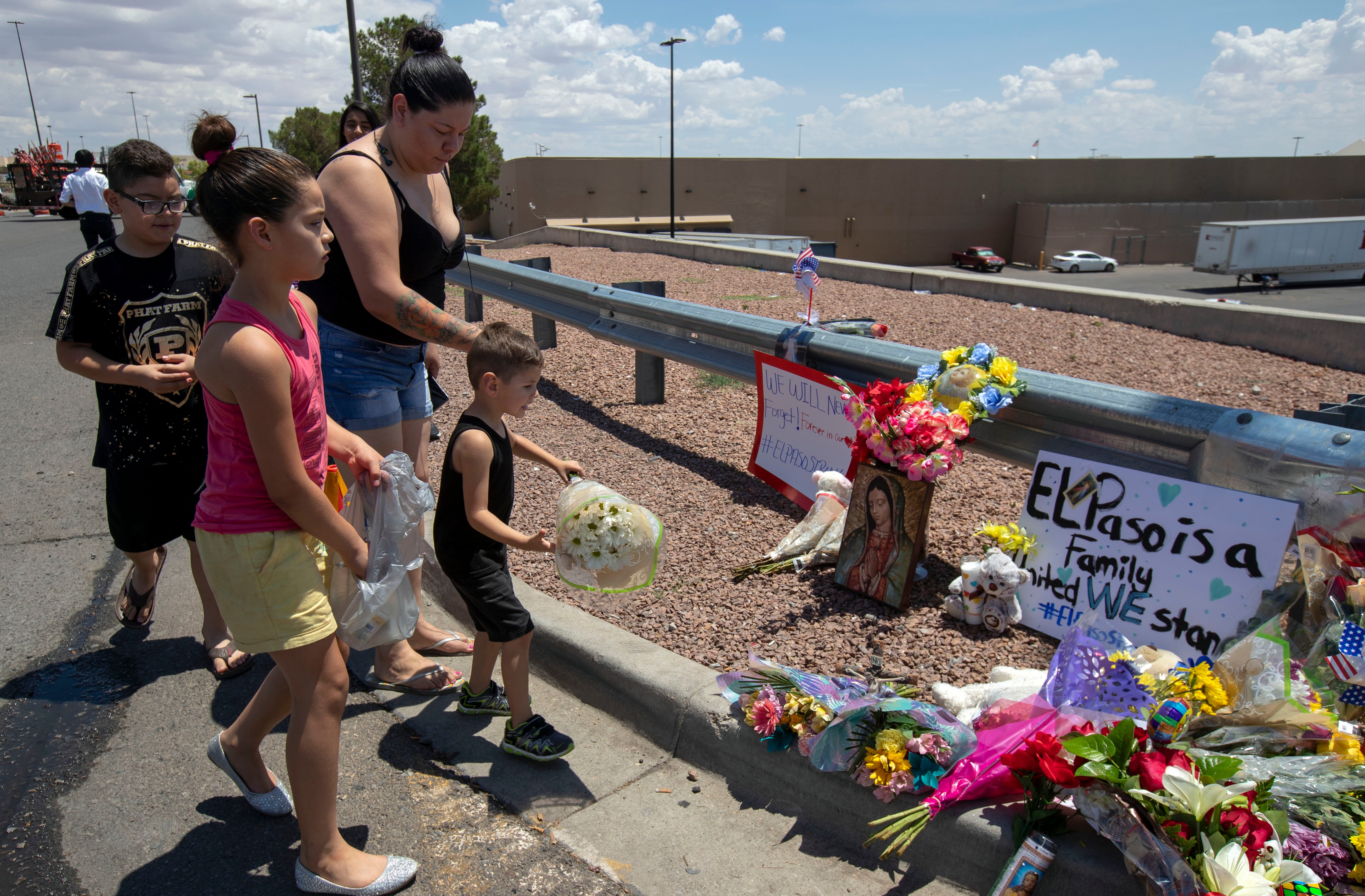 An El Paso family bring flowers to the makeshift memorial for the victims of the mass shooting in El Paso