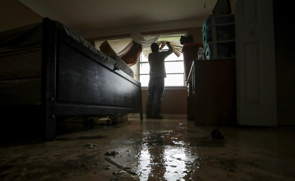Eufenio Reyes cleans out his bedroom after his Houston home flooded in May.