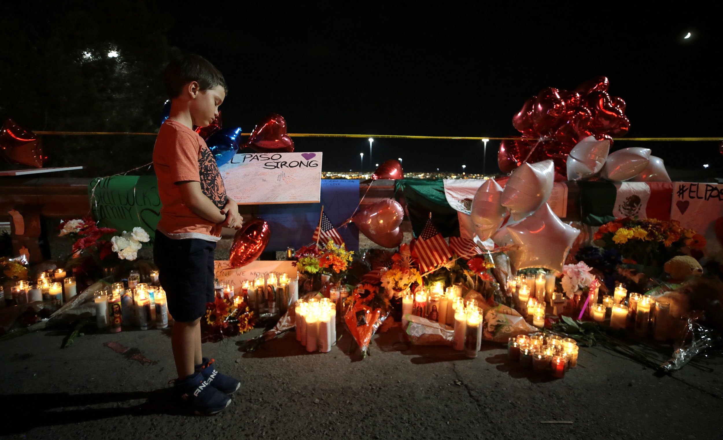 A boy reacts as he looks at teddy bears left for children killed.