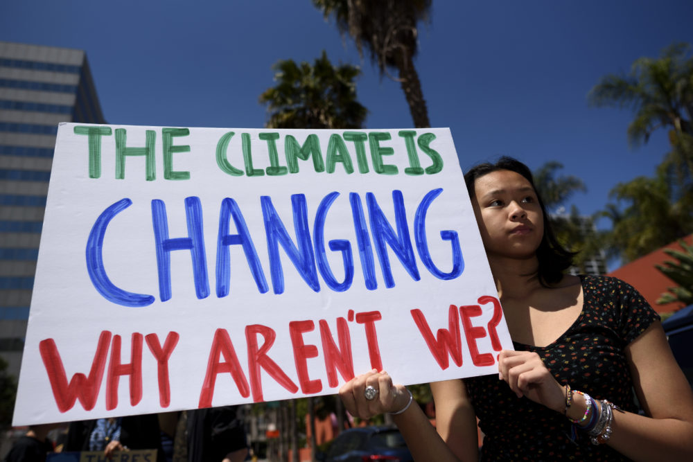 A protester is seen during a climate change demonstration holding a placard that says 'the climate is changing why aren't we?'. Students and environmental activists participate in a Climate Strike in Los Angeles, California. Organizers called on the Trump Administration to declare a state of climate emergency in order to save the planet, create a Green New Deal and transition into a zero emissions economy. (Photo by Ronen Tivony / SOPA Images/Sipa USA)(Sipa via AP Images)