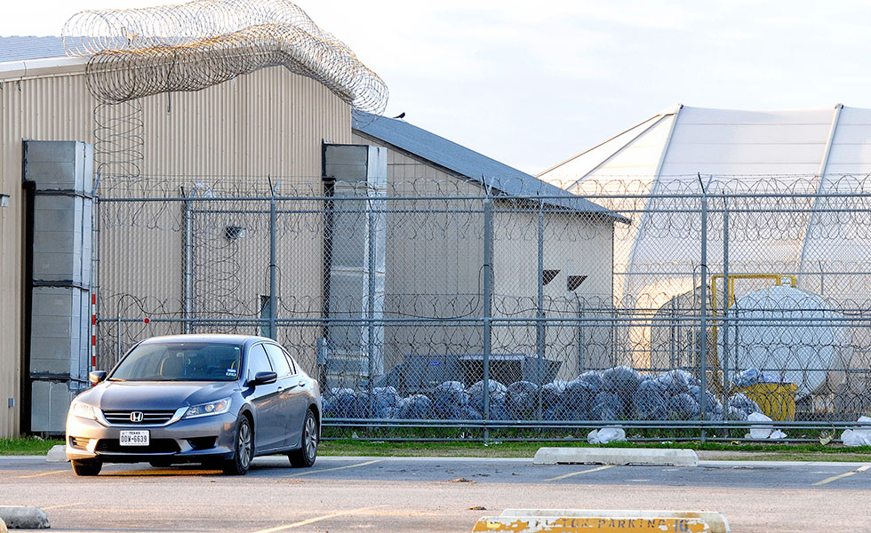 In this March 7, 2015 file photo, trash bags are piled within the northern fence at the Willacy County Correctional Center as clean up begins at the emptied detention facility in Raymondville, Texas. Management and Training Corp. recently purchased the detention center that was shuttered after a 2015 inmate riot left it uninhabitable. (David Pike/Valley Morning Star via AP, File)