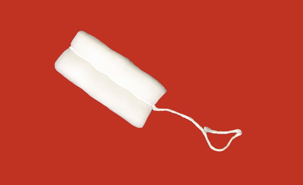 an unused tampon on a red background