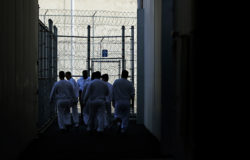 Detainees walk toward a fenced recreation area during a media tour at the U.S. Immigration and Customs Enforcement (ICE) detention facility Tuesday, Sept. 10, 2019, in Tacoma, Wash. (AP Photo/Ted S. Warren)